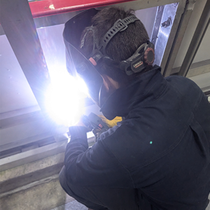 Technicien en soudure aluminium en train de fabriquer une pièce sur mesure